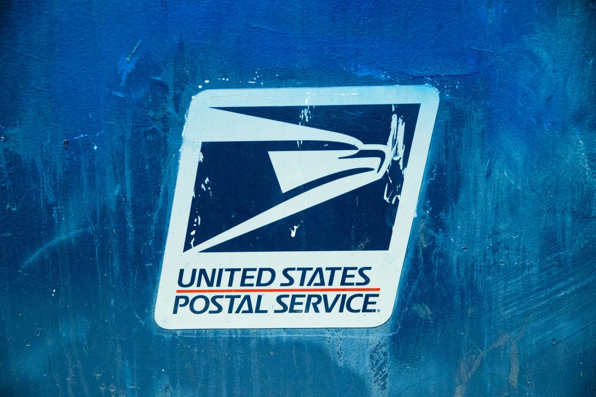 Detailed view of the United States Postal Service logo on a blue background, showcasing texture.