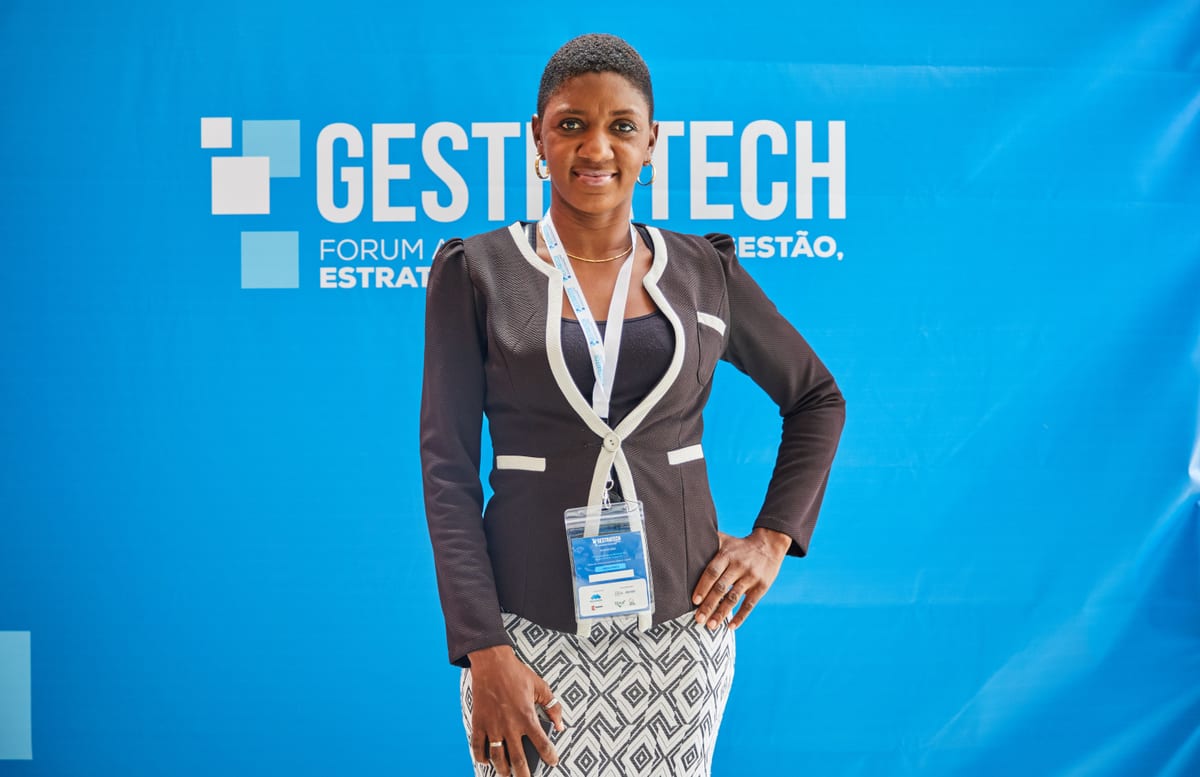 Empowered woman in business attire at a strategic forum, exuding confidence against a blue backdrop.