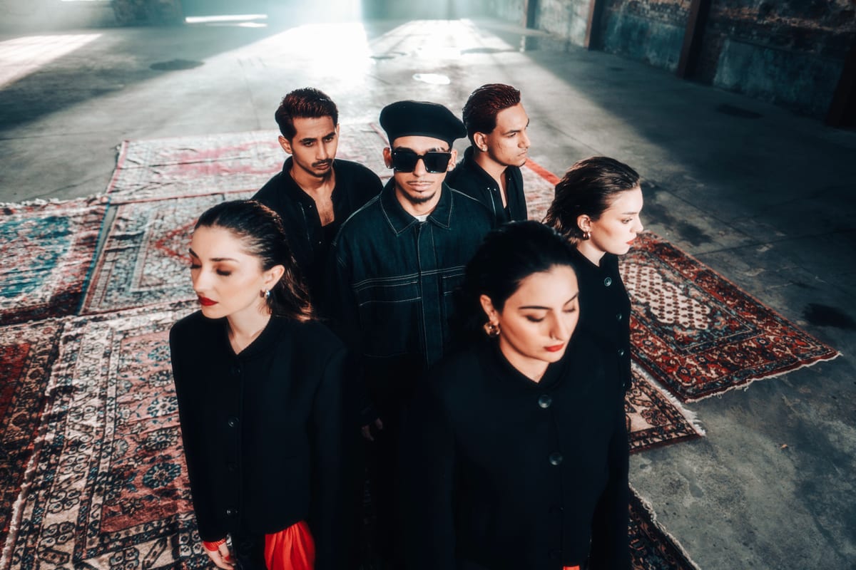 A diverse group of stylish young adults in dramatic lighting.