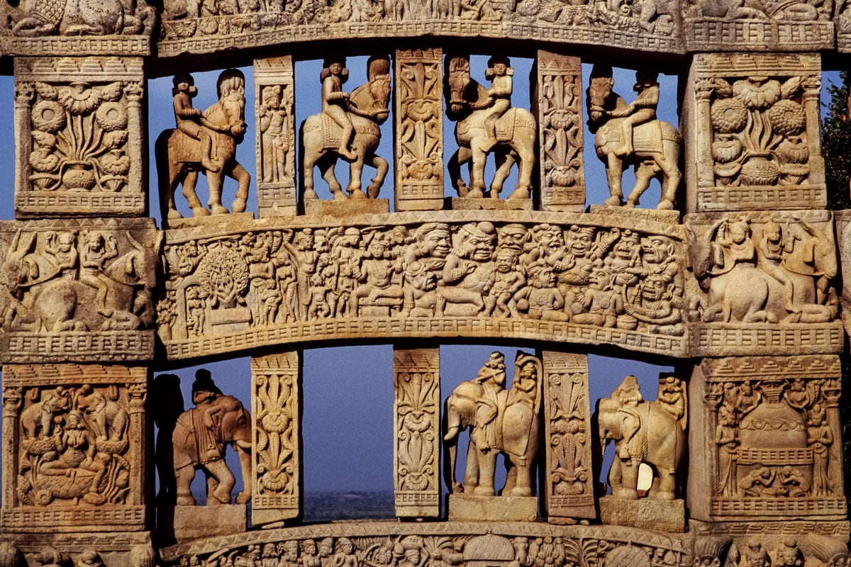 Detailed view of ancient stone carvings on the Sanchi Stupa in India, showcasing historic Buddhist art.