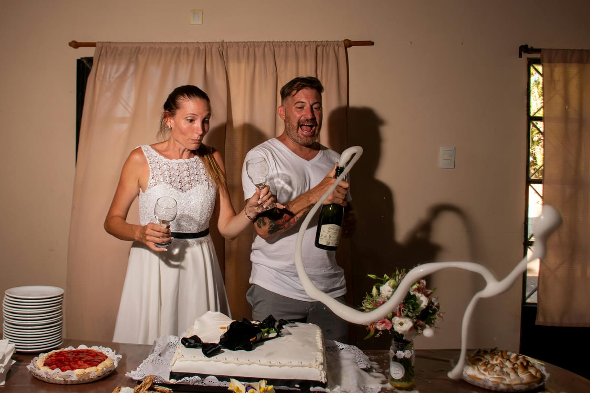 Couple celebrates with cake and champagne. Perfect for weddings or parties.
