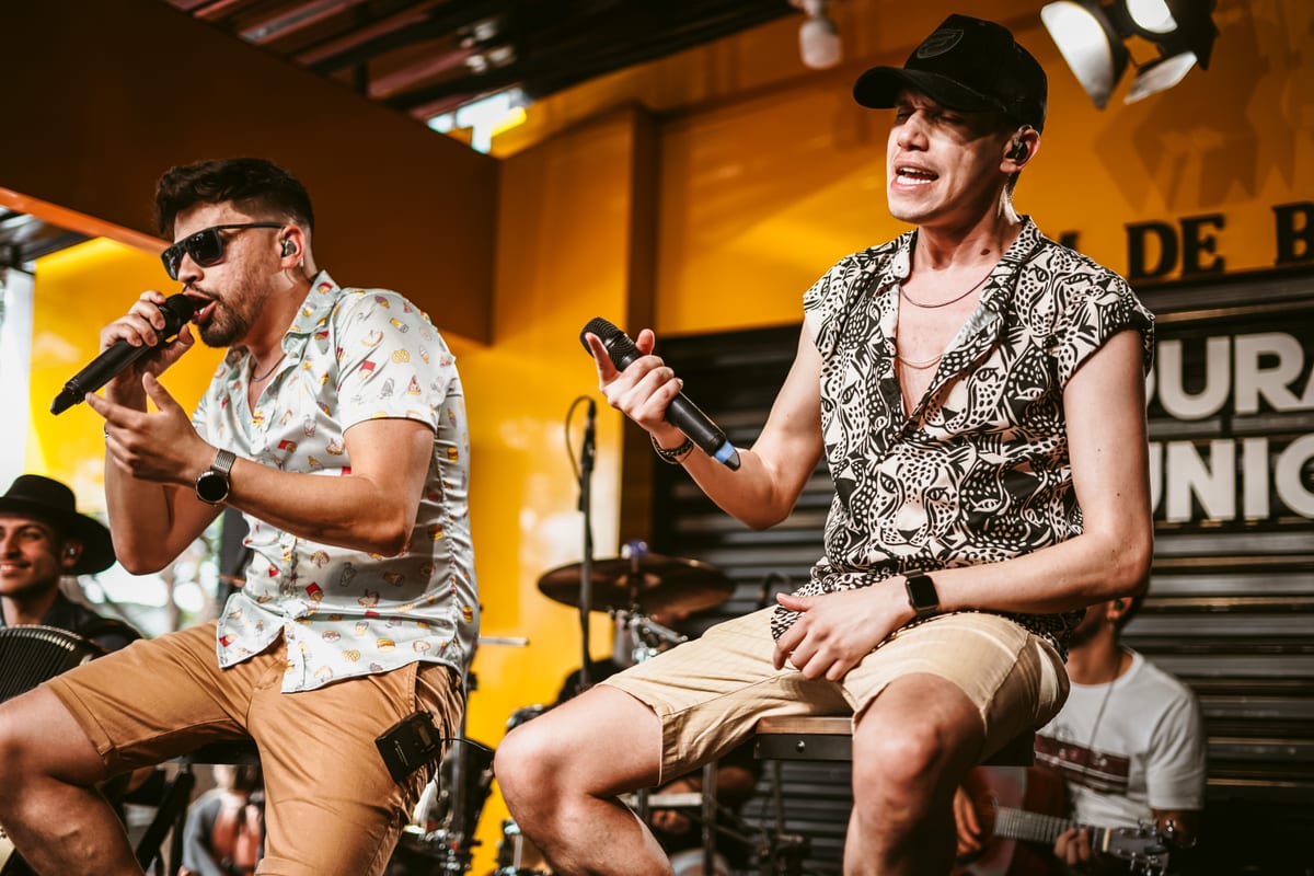 Energetic indoor performance featuring two male vocalists on stage.