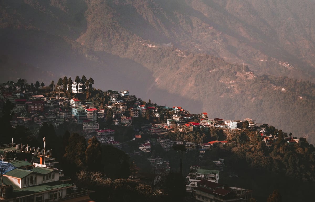 Aerial view of Darjeeling with vibrant houses nestled in the verdant hills of West Bengal, India.
