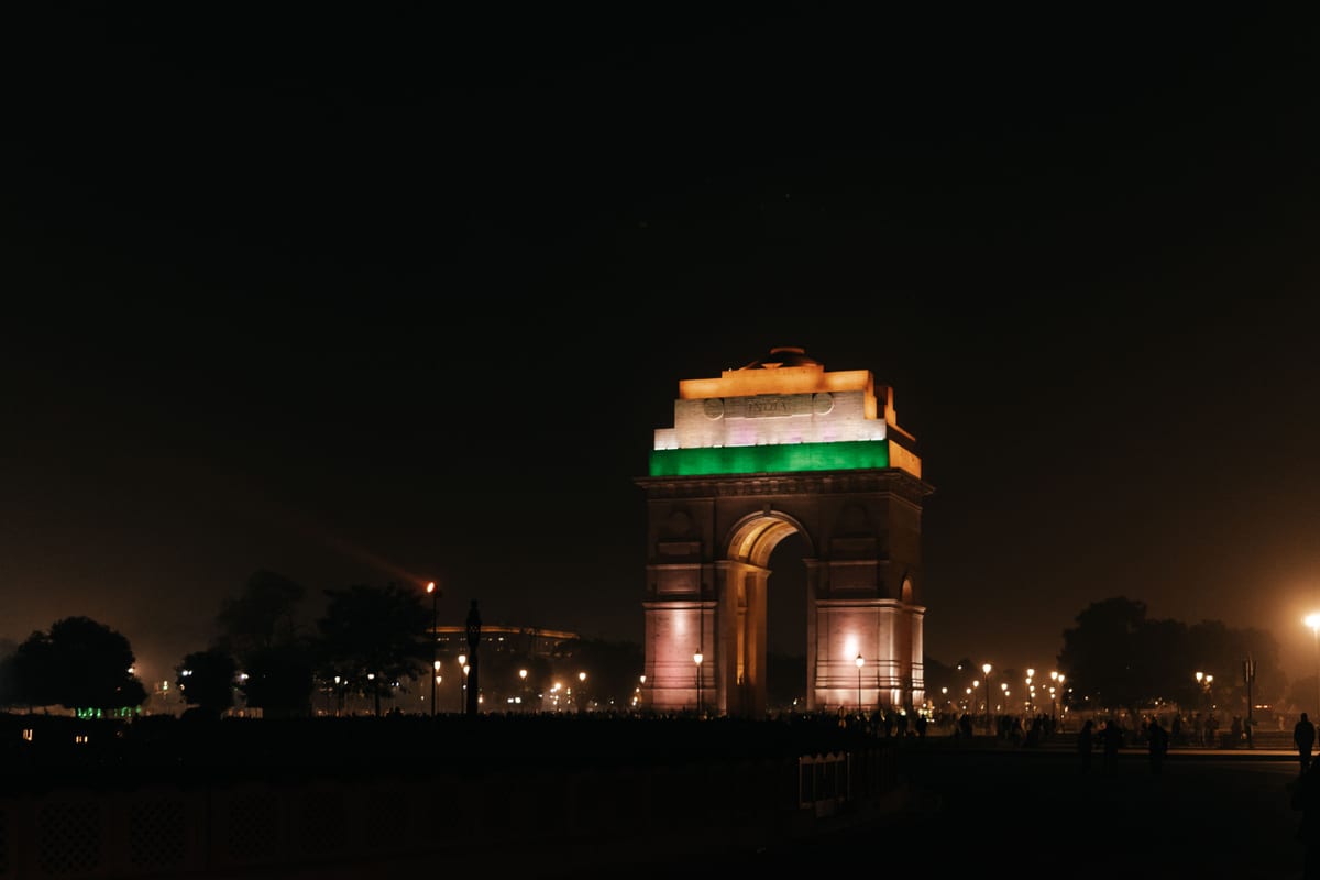 India Gate, New Delhi, beautifully illuminated at night, showcasing vibrant colors and architectural beauty.