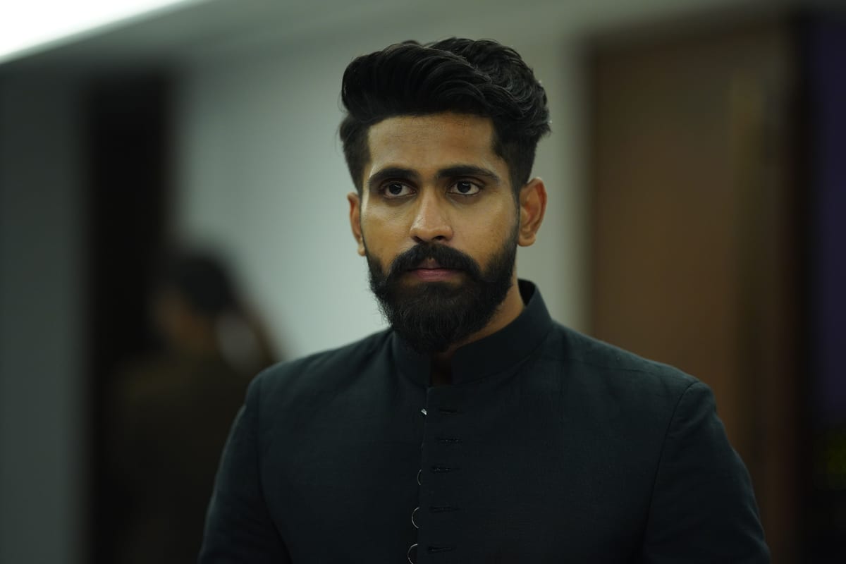 Detailed portrait of a man in a stylish black outfit taken indoors.