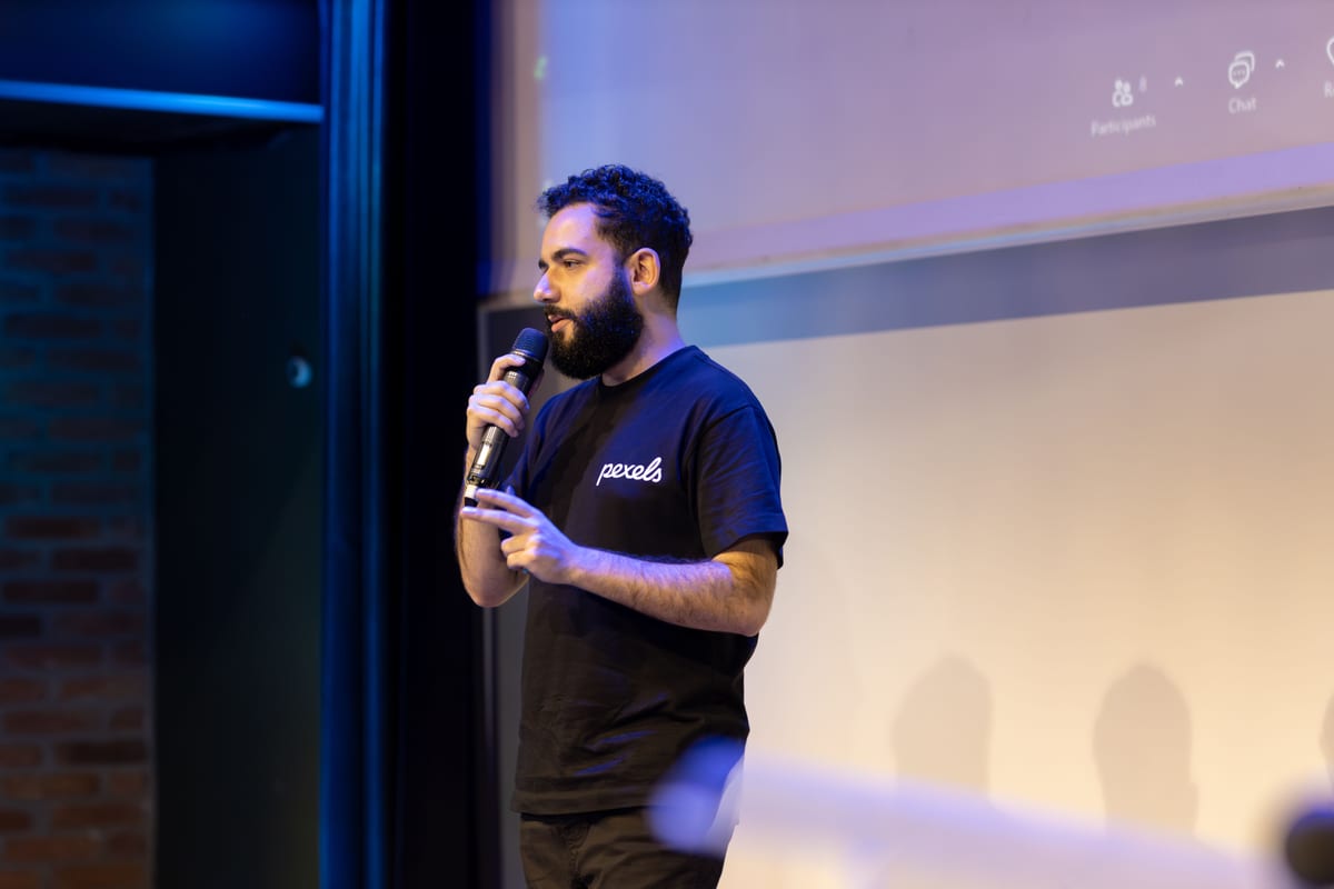 A speaker using a microphone during a presentation on stage.