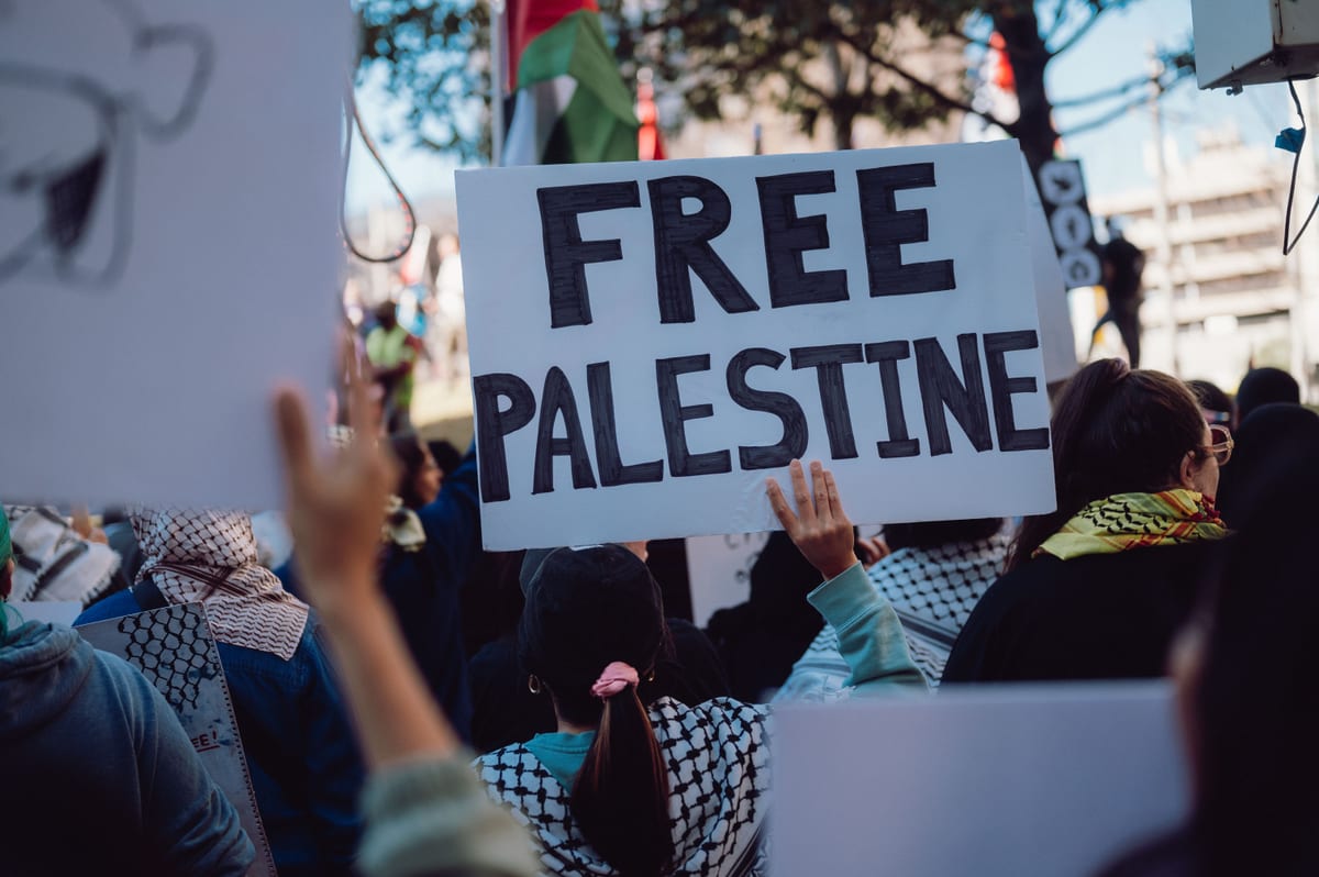 A crowd advocating for Palestinian rights holds 'Free Palestine' signs during a peaceful protest.