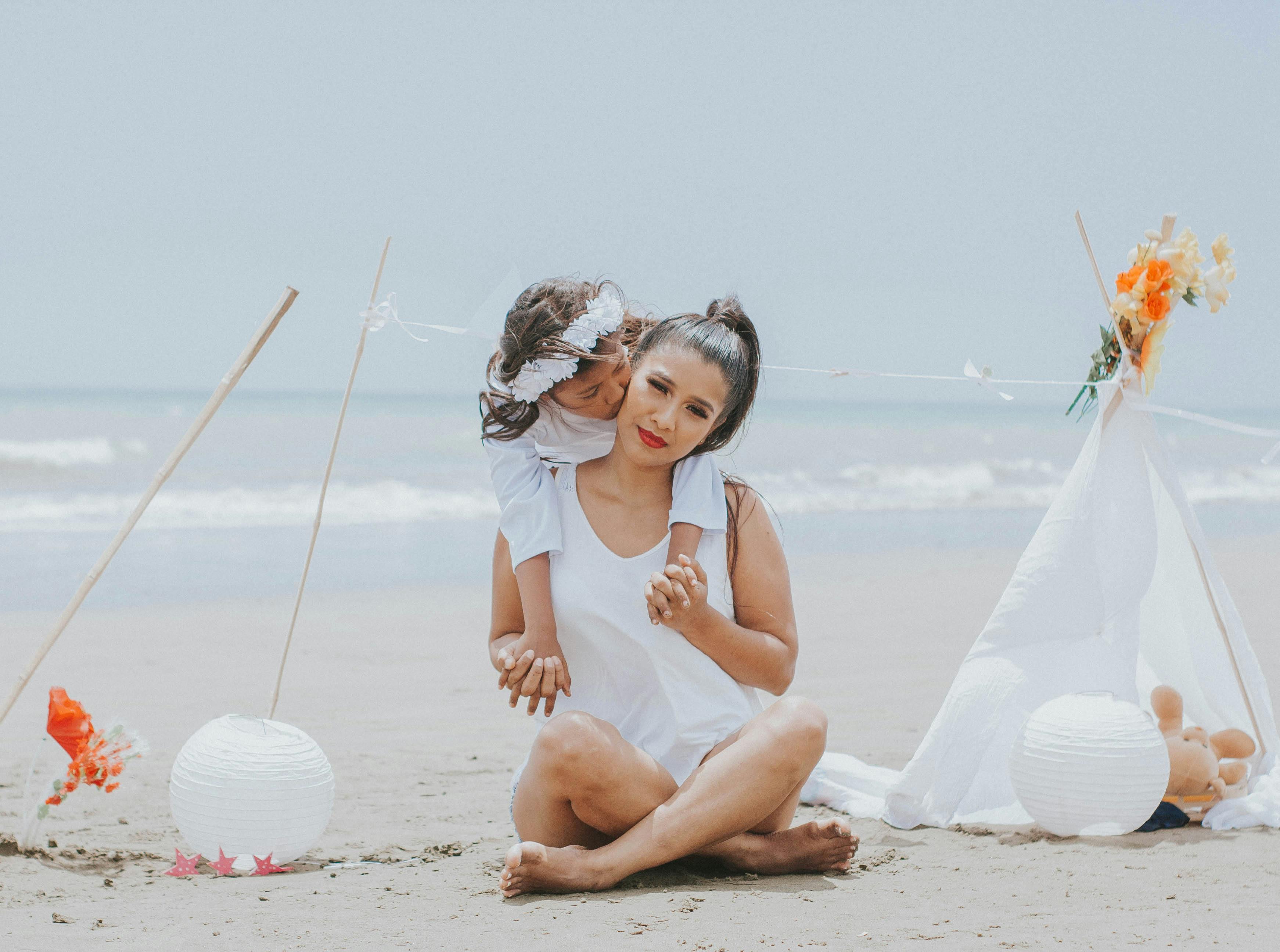A mother and daughter enjoying quality time together at a beach setting.