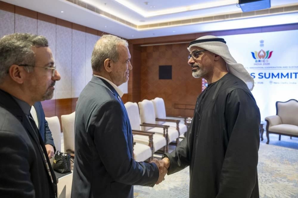 President Masoud Pezeshkian of Iran shakes hands with Sheikh Khaled bin Mohamed bin Zayed Al Nahyan, Crown Prince of Abu Dhabi, in front of the BRICS India 2026 backdrop in New Delhi