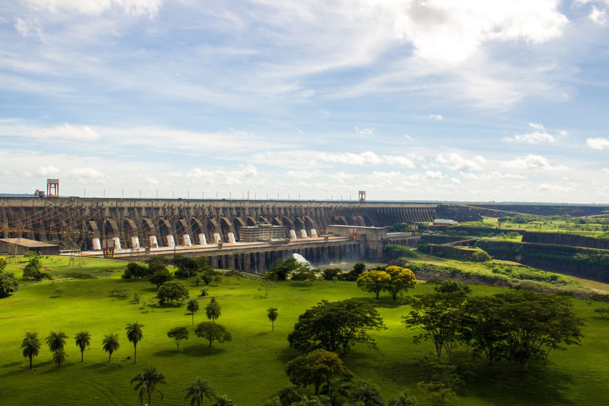 Experience the majestic Itaipu Dam surrounded by lush greenery in this scenic landscape view.