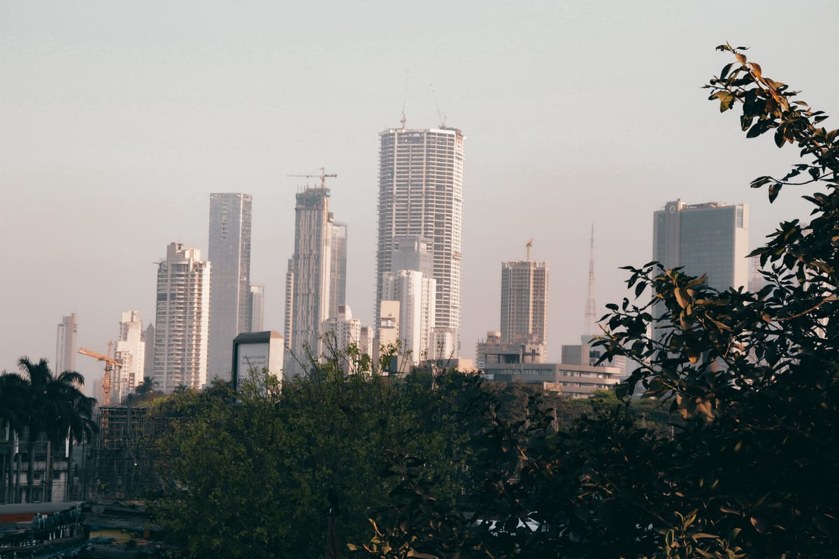 City skyline with skyscrapers and trees during the day, showcasing urban architecture.