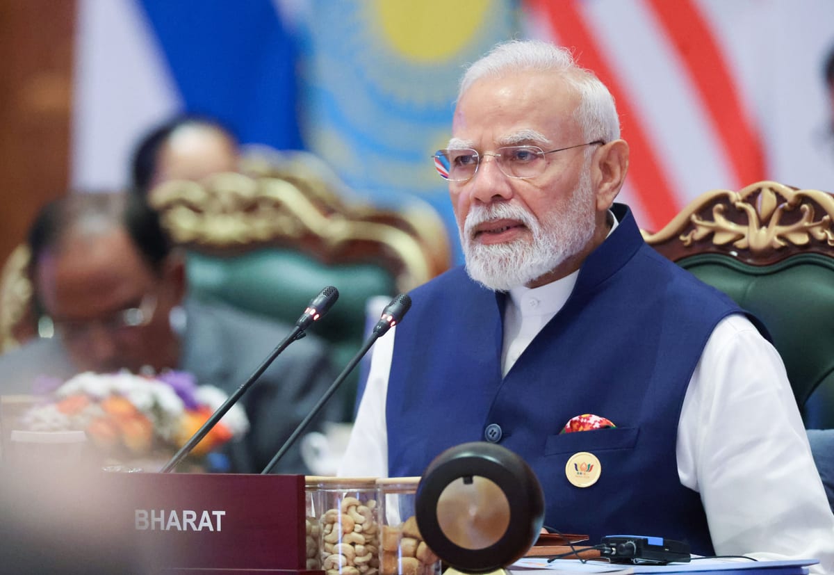 Prime Minister Narendra Modi speaking at the 18th BRICS Summit, flags of member states behind him, Bharat Mandapam, New Delhi