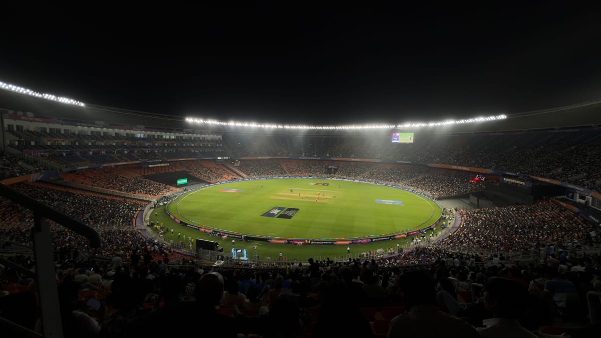 A captivating night cricket match with a large crowd at Narendra Modi Stadium in Ahmedabad, India.