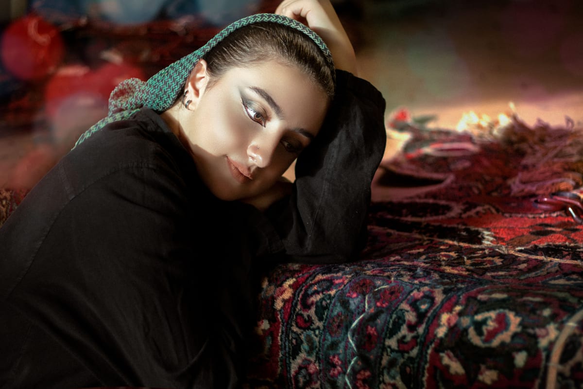 Portrait of a woman resting on a vibrant Persian carpet, embodying traditional Iranian elegance.