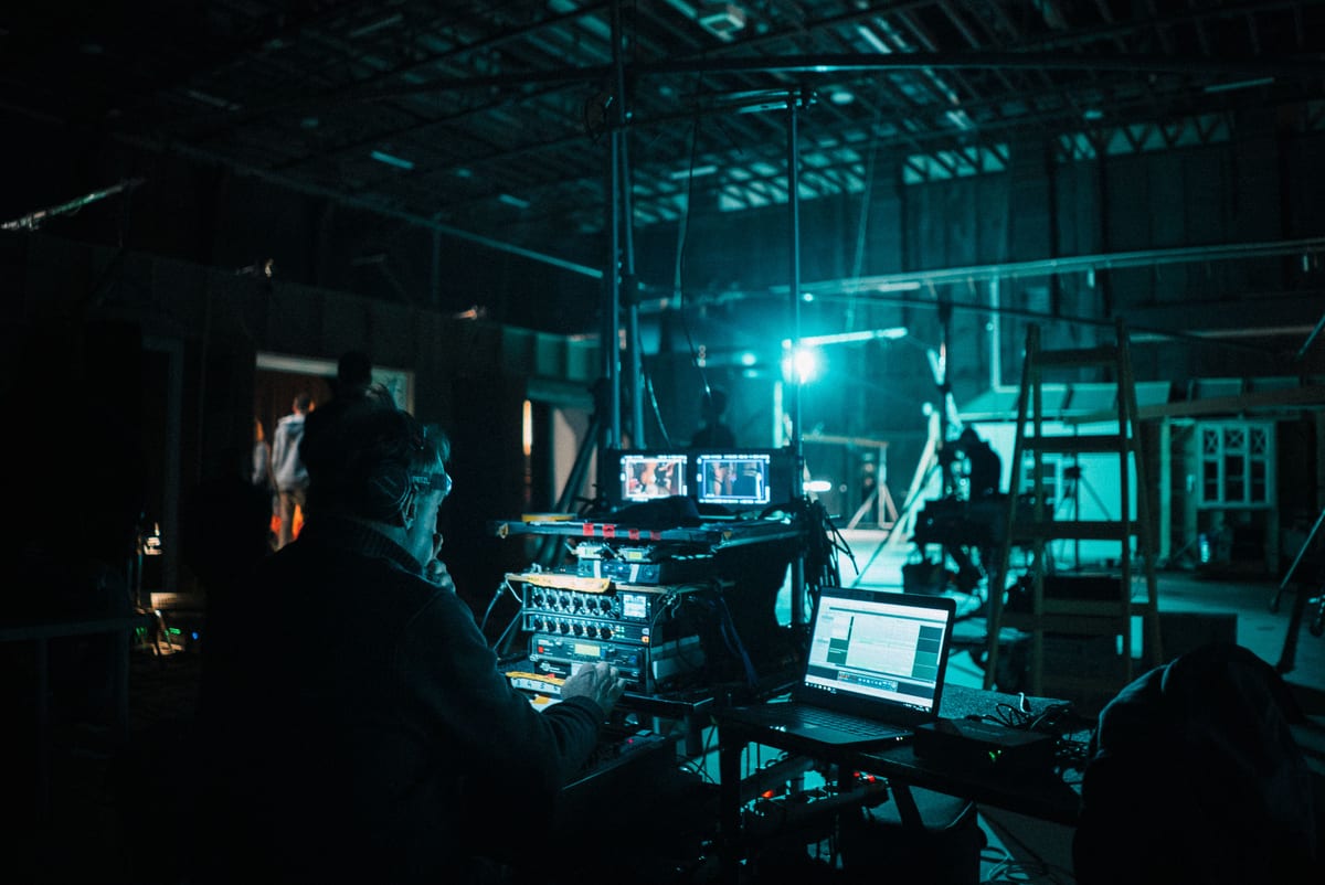 Film crew operating technical equipment on a dimly lit set in Budapest, Hungary.
