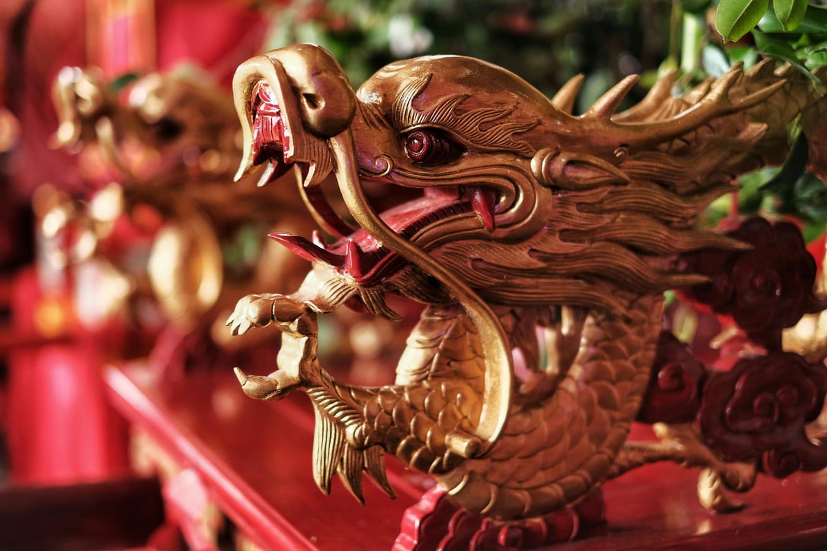 Close-up of an ornate golden dragon sculpture with red highlights, symbolizing strength and prosperity in Asian culture.