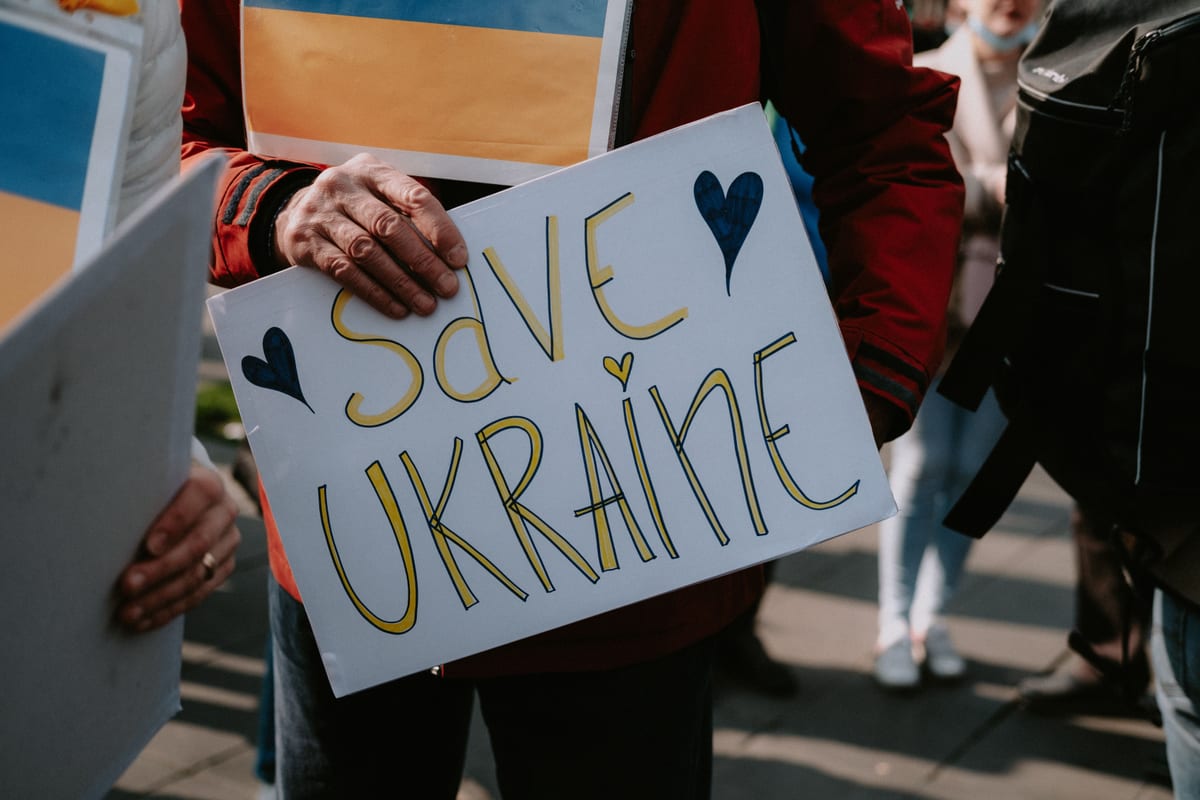 Protesters holding a Save Ukraine sign during a peaceful demonstration.