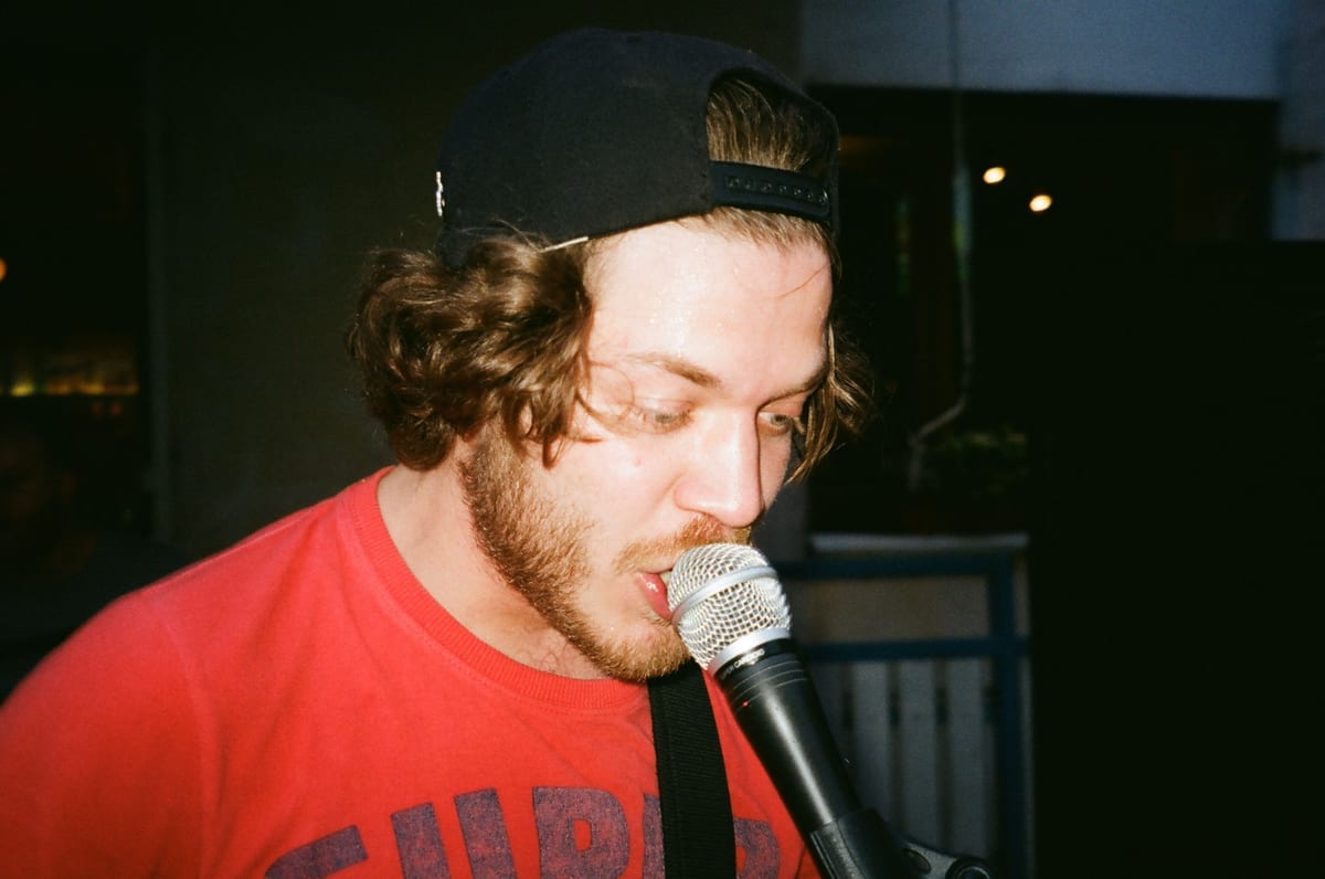 A bearded male singer passionately performing with a microphone.