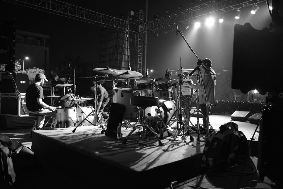 Grayscale image of band performing on stage in Ahmedabad, capturing the energy and rhythm of live music.