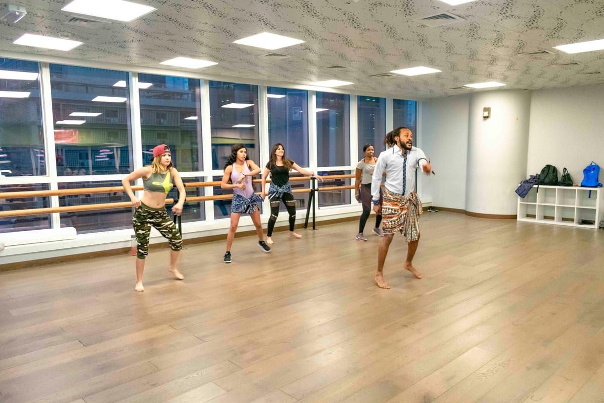 Vibrant dance class session led by an instructor in a modern studio with diverse participants.