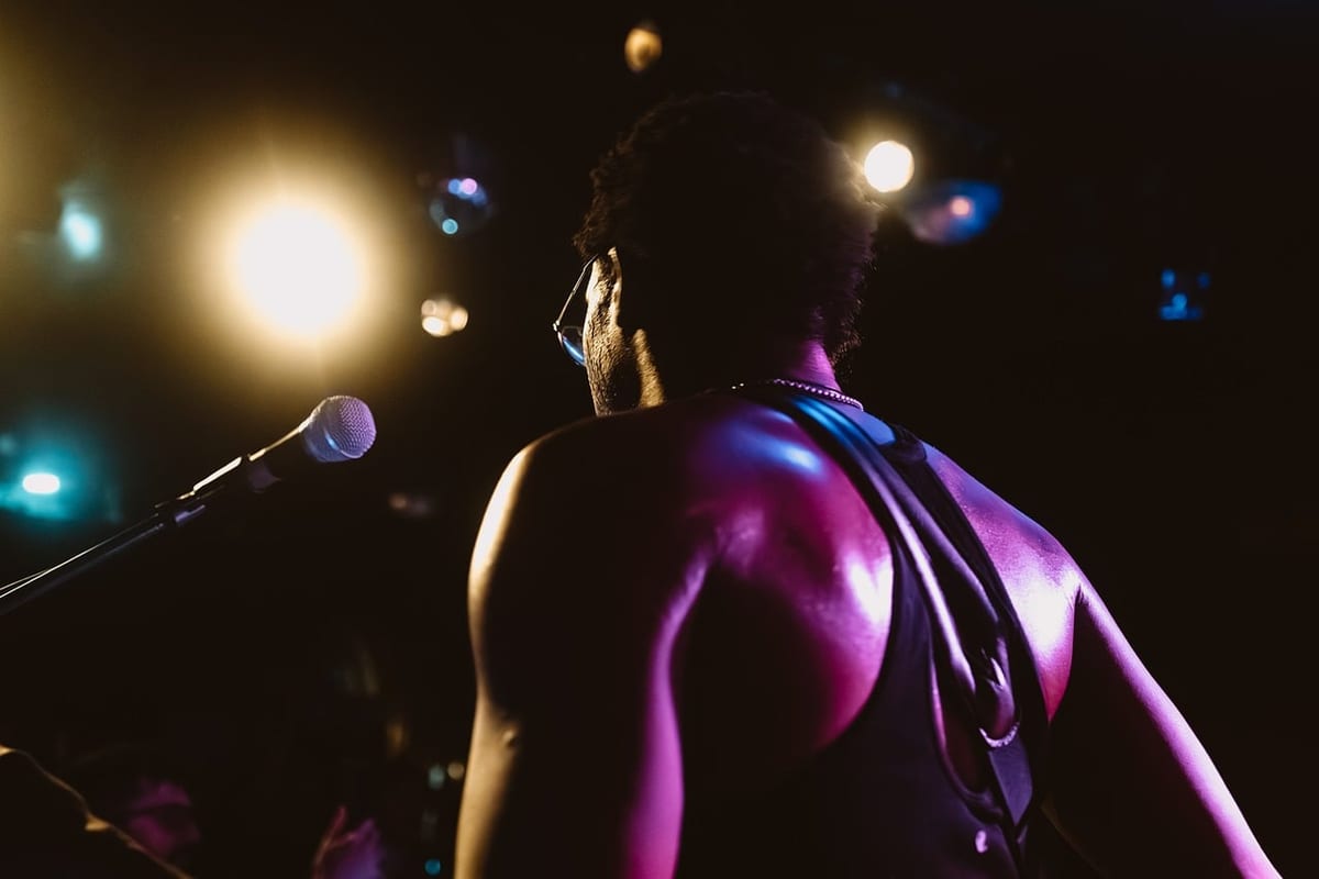concert, spotlight, musician, lifestyle, stage, electric guitar, black sunglasses, microphone, rock music, heat, crowd, dark skin tone, concert hall, orange lighting, beer, entertainment, muscles, performance, artist
