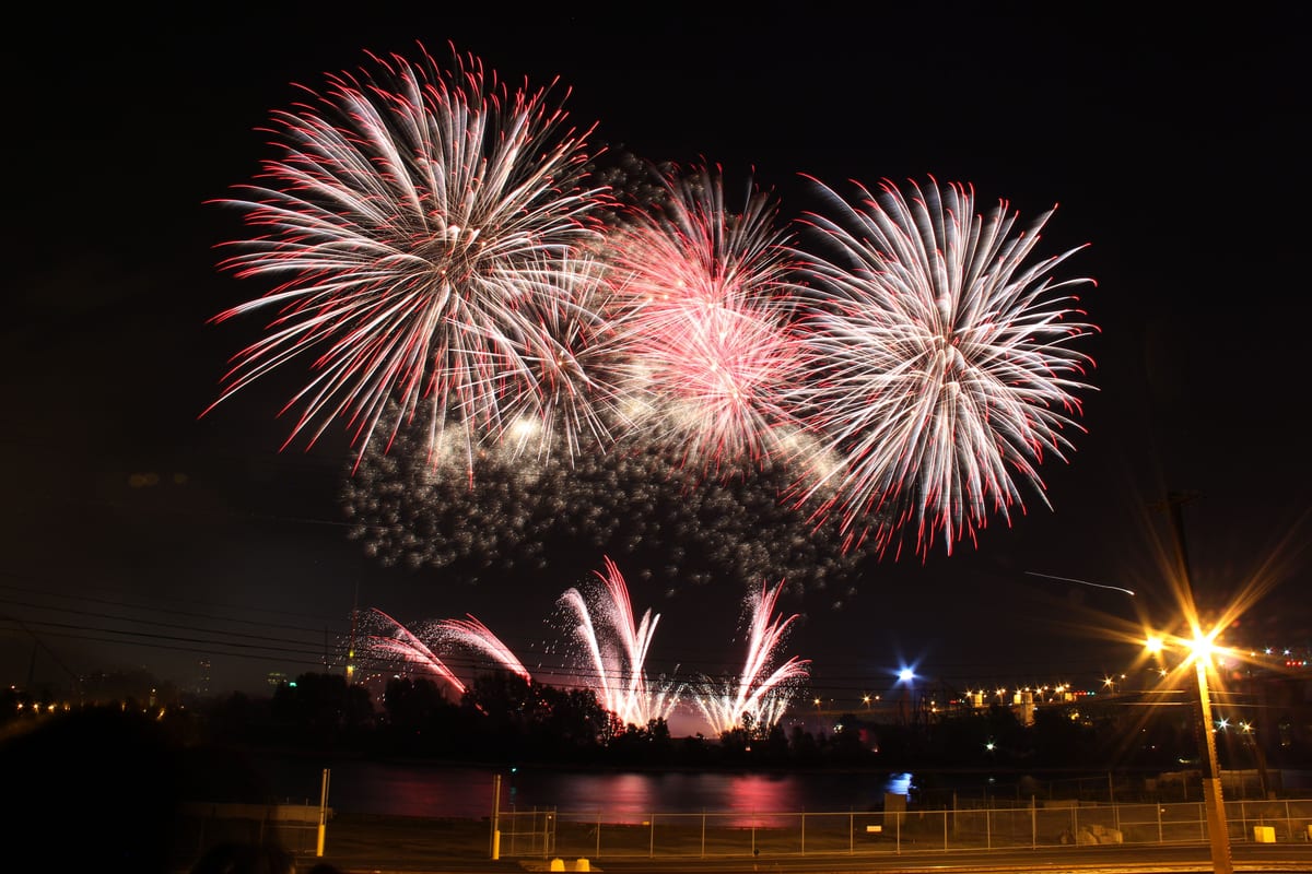 Stunning fireworks exploding over Montreal at night, illuminating the skyline.