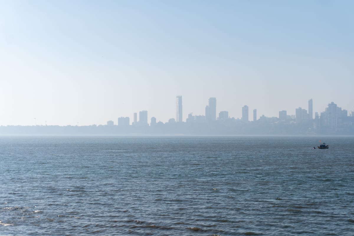 Serene view of Mumbai skyline over the Arabian Sea with distant cityscape.