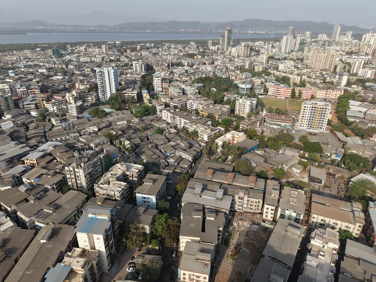 Aerial view of the dense urban landscape of Mumbai, showcasing high-rises and residential areas.