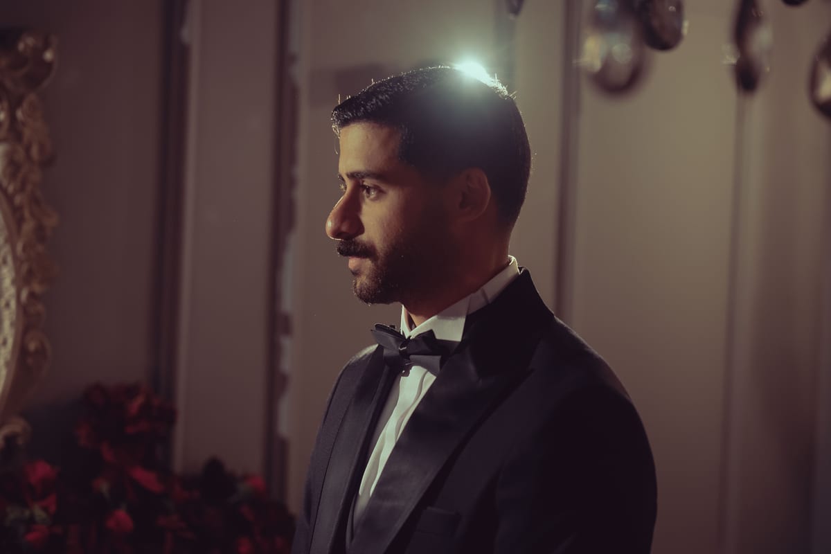 Profile portrait of a man in a tuxedo in a sophisticated indoor setting, Baghdad, Iraq.