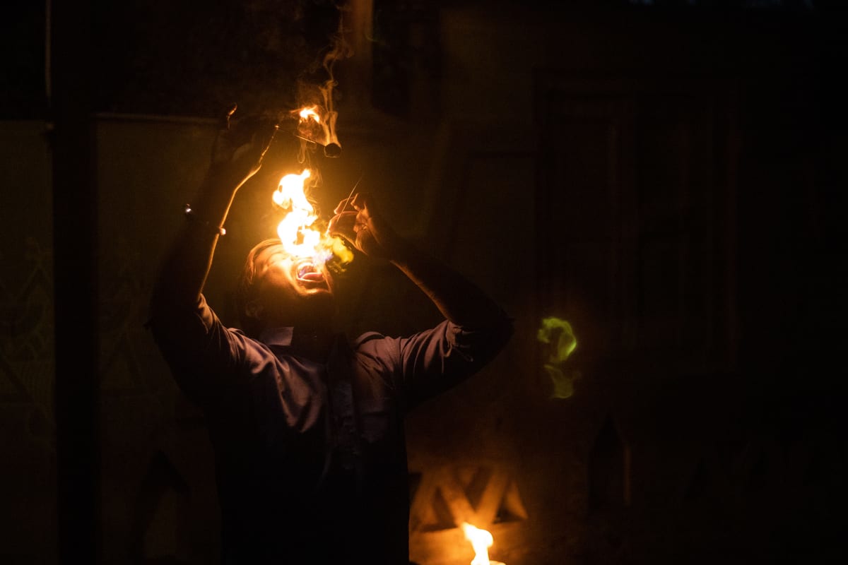 A skilled fire-eater performs a mesmerizing act, engulfing flames against the dark night.