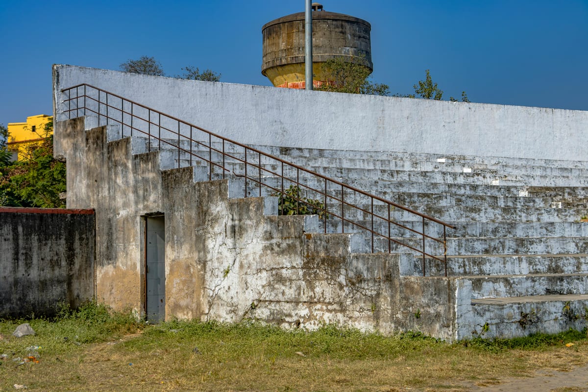Explore an abandoned stadium in Hazaribagh, showcasing brutalist architecture and urban decay.