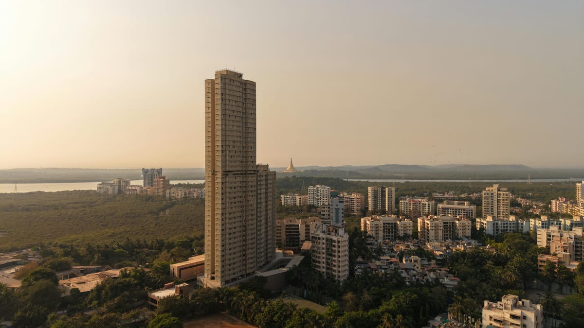 A captivating aerial shot of Mumbai's skyline with tall buildings and lush greenery at sunset.