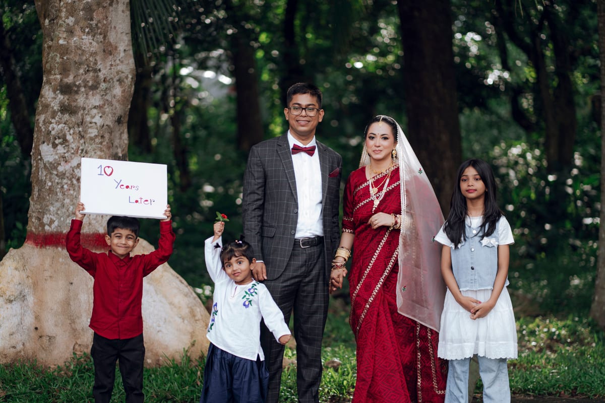 A family portrait with elegant traditional attire celebrating a 10-year anniversary outdoors.
