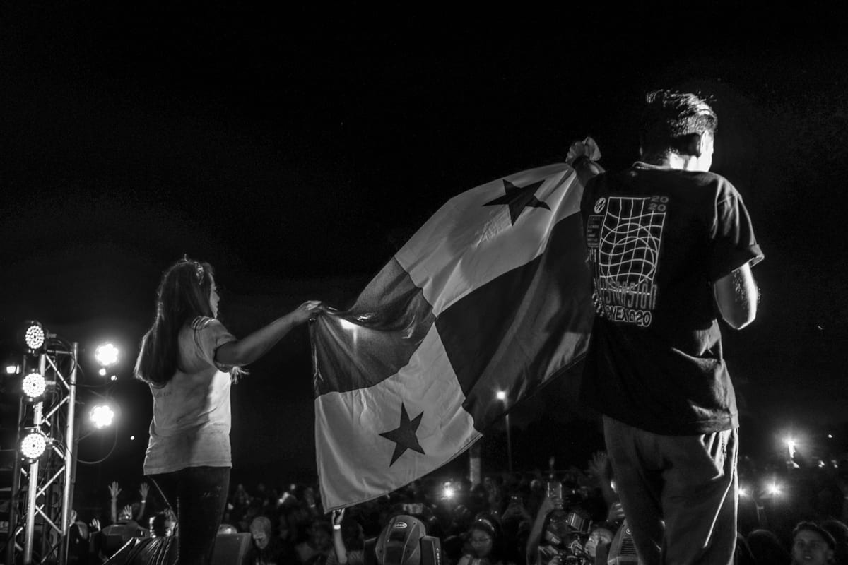 Crowd enjoys a concert with the Panama flag being waved on stage.