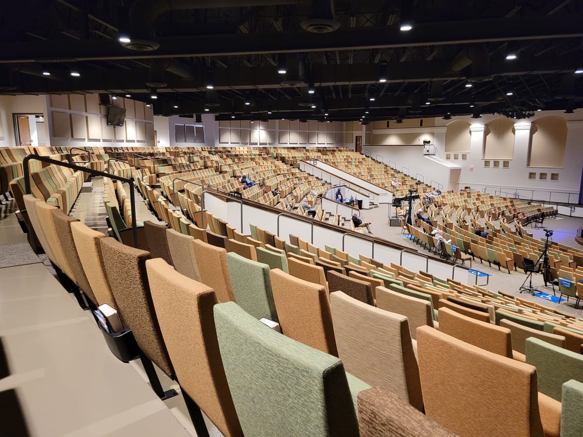 Large auditorium with tiered seating and stage setup, perfect for events or worship.