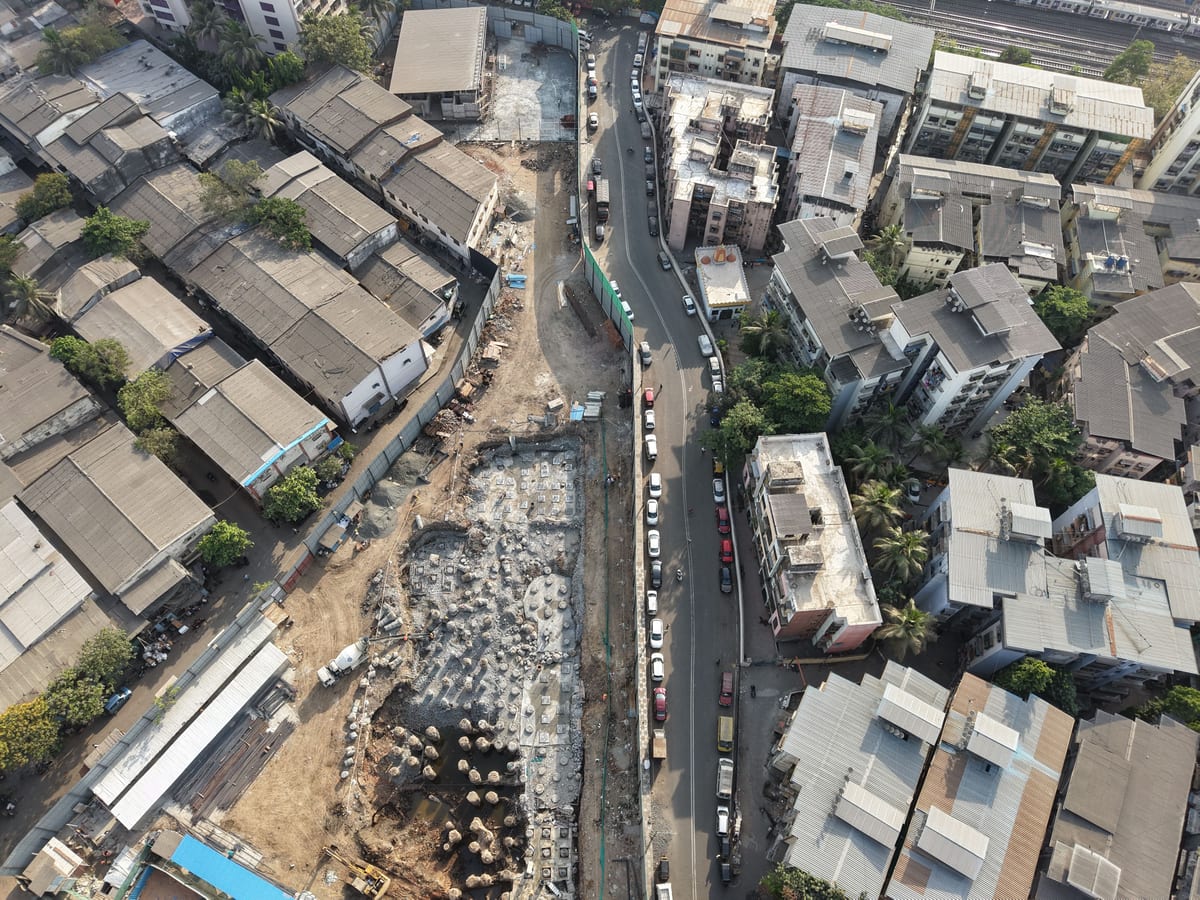 Aerial view of construction site amidst dense urban architecture in Mumbai, India.