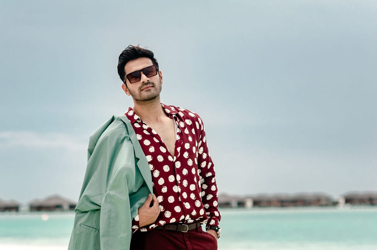Stylish man in designer outfit posing on a beautiful Maldives beach.
