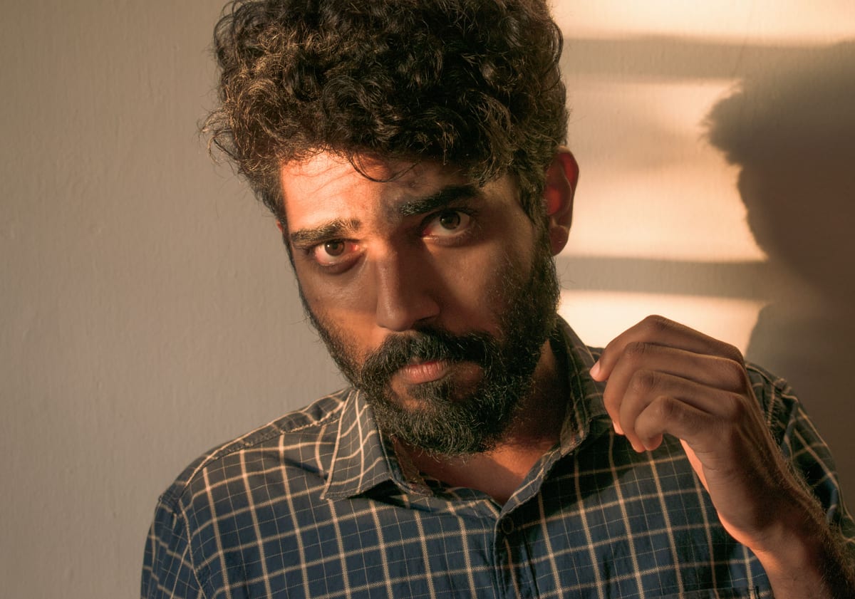 Portrait photograph of a bearded man wearing a plaid shirt with dramatic lighting and shadows.
