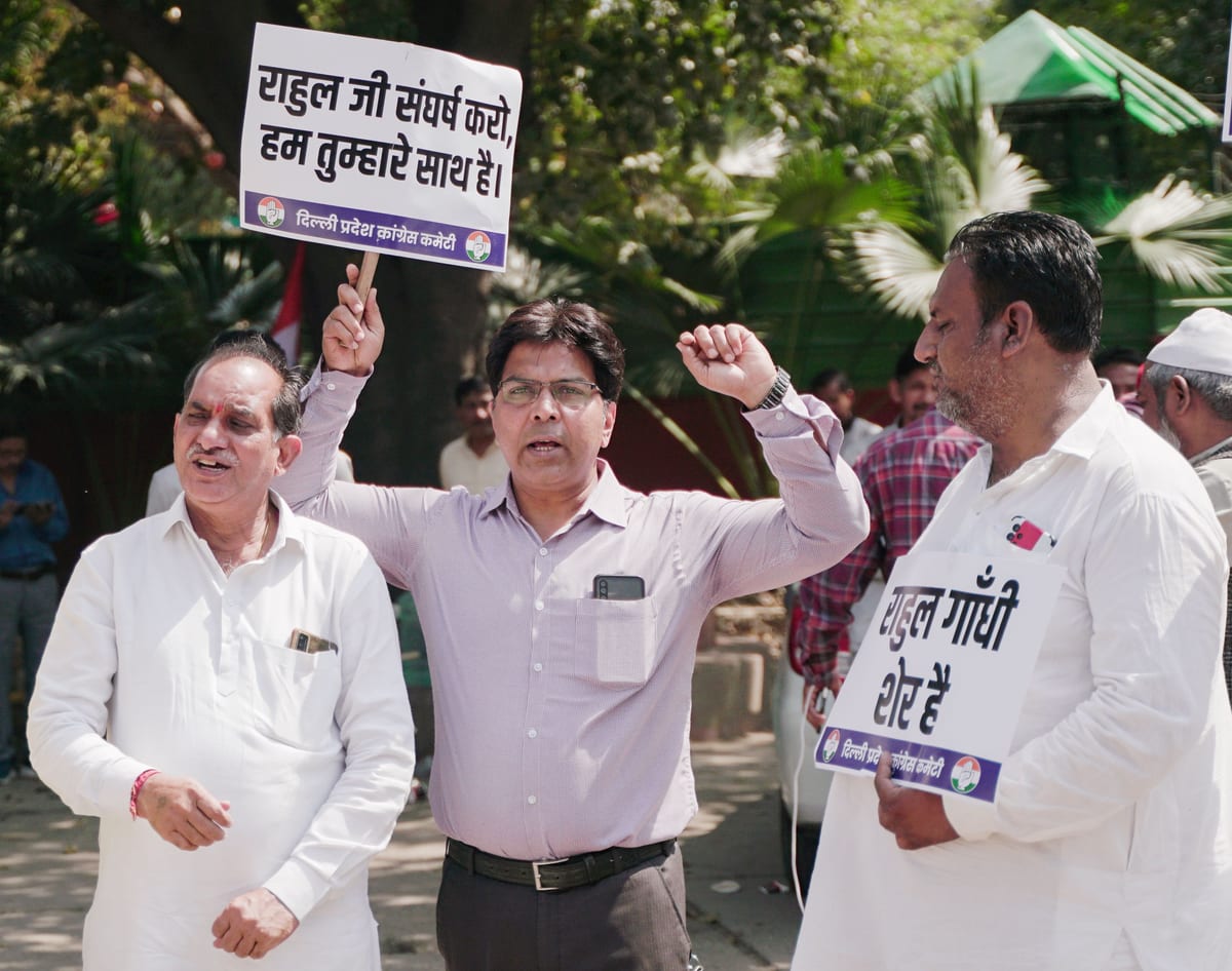 A group of men holding signs in an outdoor political protest.