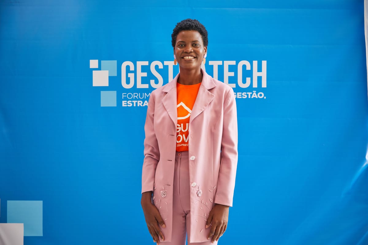 Elegant African woman smiling at a business event. Captured in front of a vibrant blue backdrop.