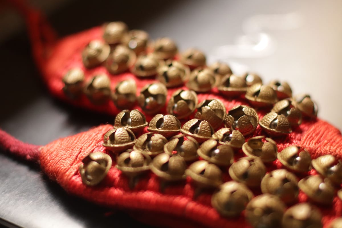 A detailed close-up of a traditional anklet with bells, showcasing intricate craftsmanship.